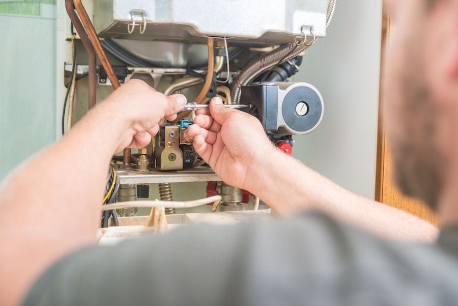 Image of someone working on a furnace. What Are Signs I Need a New Furnace?