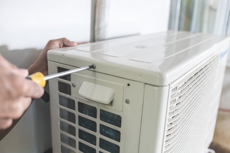 5 Common AC Problems. A technician unscrews the top hatch of the outdoor compressor unit of a Split type air conditioner. Repair or maintenance work.