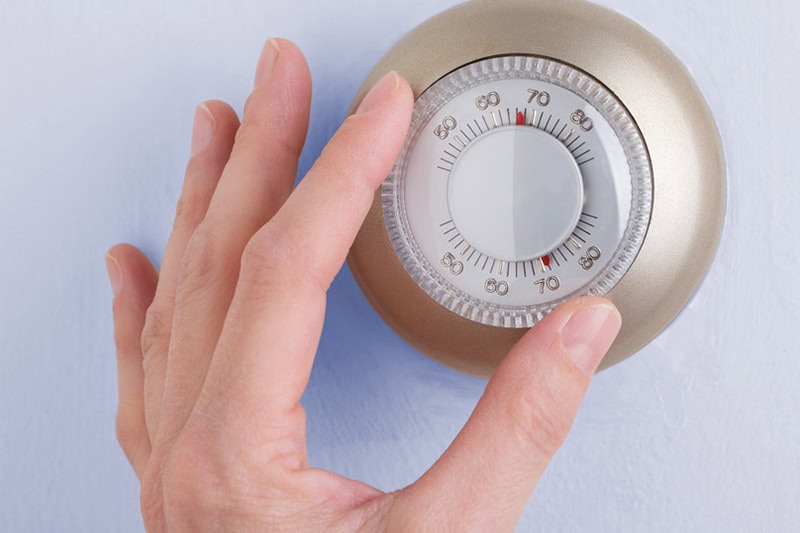 Person Adjusting Thermostat