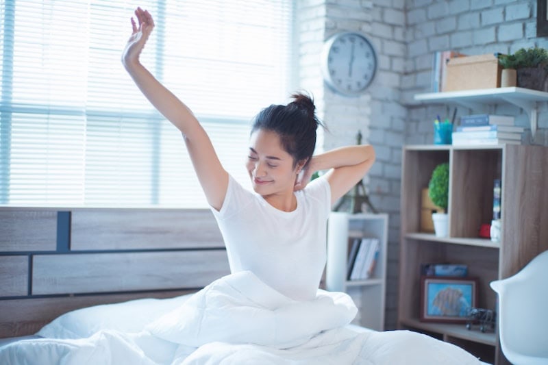 Your HVAC System Can Enhance Sleep. A women She is in bed and was waking up in the morning. She felt very refreshed.