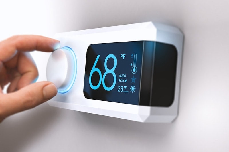 man changing thermostat temperature